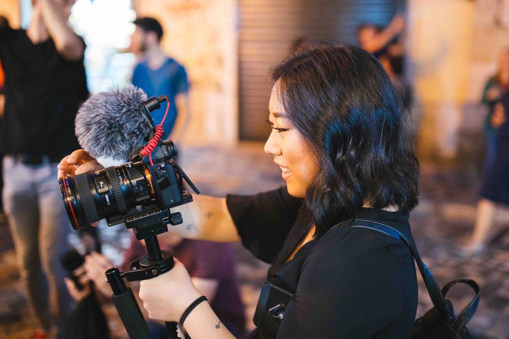In the next normal, video content is a highly effective medium. That's exactly what this young woman is doing, shooting an event with her videocam