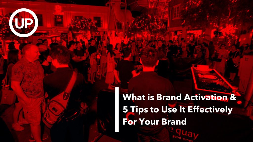 Text what is brand activation & 5 tips to use it effectively for your brand on a red filtered photograph of people partying at Clarke Quay